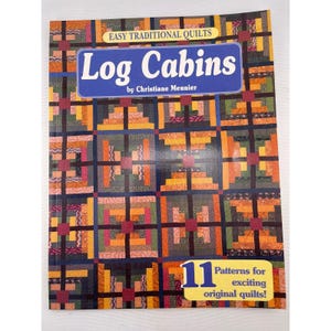 Pode incluir: Um livro intitulado "Log Cabins" de Christiane Meunier, com um padrão de colcha colorido na capa. Faz parte da série "Easy Traditional Quilts" e inclui 11 padrões para colchas originais. O design da capa incorpora quadrados de várias cores.