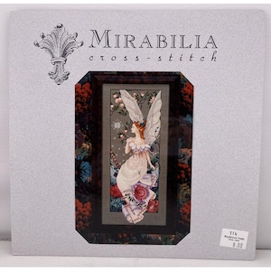 Könnte beinhalten: Ein Mirabilia Kreuzstich-Set mit einem gerahmten Design einer Fee mit rotem Haar und großen weißen Flügeln, die ein fließendes Kleid trägt. Das Set enthält den Text "Mirabilia cross-stitch" und einen dekorativen floralen Rand.