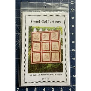 May include: A pattern for a redwork birdhouse wall warmer, packaged in plastic. The pattern is labelled "Sweet Gatherings" and shows nine birdhouse designs. The finished wall warmer measures 89 x 99 cm.