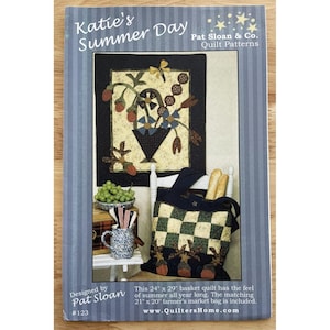 Pode incluir: Um padrão de colcha intitulado "Katie's Summer Day" de Pat Sloan. A capa apresenta uma imagem acolchoada de uma cesta com flores e uma sacola de feira combinando. A colcha mede 61 cm x 74 cm, e a sacola tem 53 cm x 51 cm.