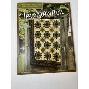 Peut inclure: Couverture de livre avec le titre "Imagination" en écriture cursive. La couverture présente un patchwork avec un motif d'étoiles dans les tons de vert, marron et crème, accroché à une porte en bois. Le haut de la couverture indique "Gathering Friends".