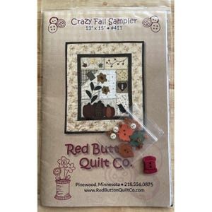 Può includere: Un kit quilt Crazy Fall Sampler, 33 x 38 cm, con un design patchwork con zucche, fiori e un uccello. Il kit include bottoni e una bobina di filo. La confezione è di Red Button Quilt Co.