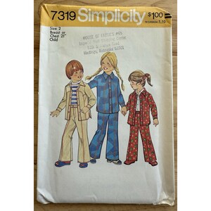 May include: A vintage Simplicity sewing pattern, size 2, featuring illustrations of children's outfits. The pattern includes a jacket and pants set, a plaid shirt and pants set, and a red floral shirt and pants set. The pattern is from House of Fabrics.