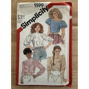 May include: Vintage Simplicity sewing pattern, size 10 Miss, featuring illustrations of blouses. The pattern envelope is red and white with the Simplicity logo and the number 5599. The illustrations show different blouse styles.
