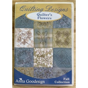 May include: A DVD case featuring a patchwork design of floral patterns in shades of blue, green, and beige. The text "Quilting Designs" and "Quilter's Flowers" are displayed at the top. The bottom of the case reads "Anita Goodesign Full Collection."