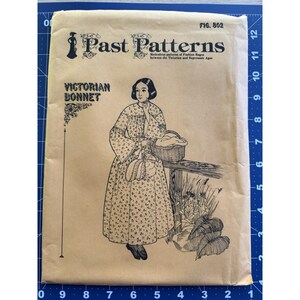 May include: A vintage sewing pattern titled "Past Patterns" featuring a Victorian bonnet design. The illustration shows a woman in a long dress, holding a basket and a purse. The pattern is printed on tan paper with black ink.