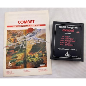 May include: An Atari Combat video game cartridge and instruction manual. The black cartridge has the game title and game variations listed. The instruction manual features illustrations of planes and tanks.