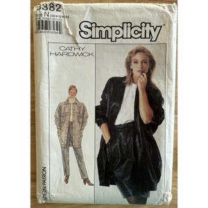 Può includere: Cartamodello Simplicity, design Cathy Hardwick, taglie 10, 12 e 14. La copertina mostra una donna con giacca e pantaloncini in pelle nera, e un'altra con giacca e pantaloni beige. Taglie europee 38, 40 e 42.
