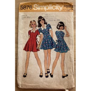 May include: Vintage Simplicity sewing pattern 5876. The pattern features illustrations of three girls wearing dresses. The pattern includes sizing information for a size 10 with a 28 1/2 inch bust. The pattern is for girls.