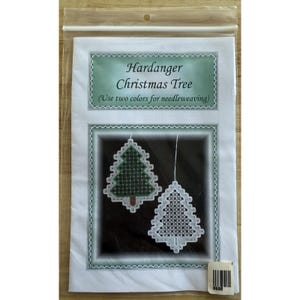 May include: A package featuring a Hardanger Christmas Tree needleweaving pattern. The design includes two Christmas tree ornaments, one green and one white, with detailed cross-stitch patterns. The text reads "Hardanger Christmas Tree" and "(Use two colors for needleweaving)."