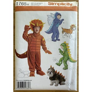 May include: Simplicity pattern 1765A showing children's dinosaur costumes. The pattern includes instructions for a brown triceratops, a blue dragon, a green dinosaur, and a dog costume. Sizes 3-8.