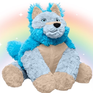 May include: A plush stuffed animal resembling a wolf or dog, featuring bright blue fur on the head and back, light blue fur on the face and arms, and tan-coloured paws, ears, and chest panel. The toy has a black nose and embroidered eyes.