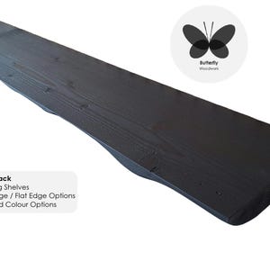 May include: A black wooden floating shelf with a live edge. The shelf is made of reclaimed wood and has a natural, rustic look. The text "Matt Black" is visible in the image. The text "Floating Shelves" is visible in the image. The text "Live Edge / Flat Edge Options" is visible in the image. The text "Size and Colour Options" is visible in the image.