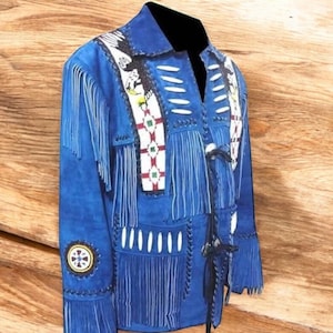 May include: A blue suede jacket with fringe detailing and decorative beadwork. The jacket features a notched collar, long sleeves, and a button closure. The design includes white, red, and green accents, and a circular emblem on the sleeve.
