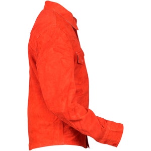 May include: A bright orange suede shirt with a button-down collar and long sleeves. The shirt has a single chest pocket and button cuffs.