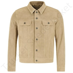 May include: A tan suede jacket with a classic collar and button-down fastening. The jacket has two chest pockets with button closures and two side pockets. The jacket is a neutral colour and has a tailored fit.