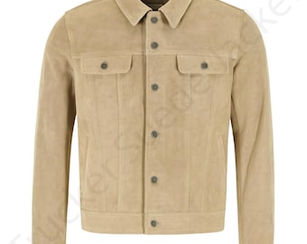 May include: A tan suede jacket with a classic collar and button-down closure. The jacket features two chest pockets with button closures and two side pockets. The jacket is a neutral color and has a tailored fit.