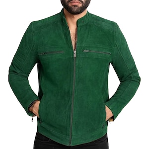 Puede incluir: Chaqueta de ante verde con cremallera y cuello alzado. La chaqueta tiene dos bolsillos con cremallera en el pecho y dos bolsillos para las manos. Las mangas tienen detalles acolchados en los hombros. La chaqueta es de color sólido.