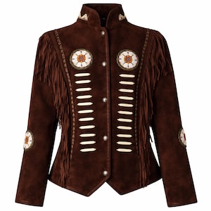 Peut inclure: Veste en daim marron avec des franges sur les manches et le dos. La veste présente des écussons floraux décoratifs et des perles blanches. Le col et les épaules ont des motifs brodés. Fermeture boutonnée.