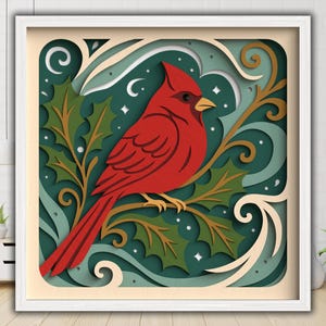 May include: A framed, layered paper art piece featuring a vibrant red cardinal perched on a branch with green holly leaves. The background has a teal and cream color scheme with decorative swirls and stars. The artwork is encased in a white frame.