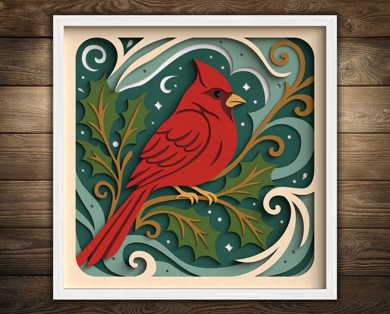 May include: A framed, layered paper art piece featuring a vibrant red cardinal perched on a branch with holly leaves. The background has shades of teal, cream, and gold, with a white frame. The artwork has a festive, nature-inspired theme.