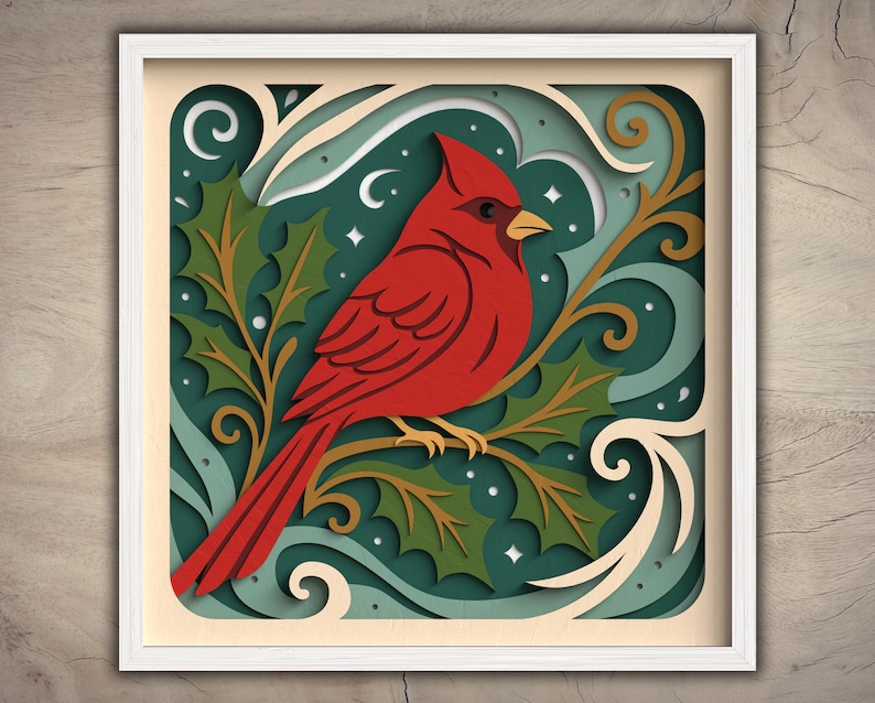May include: A framed paper art piece featuring a vibrant red cardinal perched on a branch with green holly leaves. The artwork has a layered design with a teal background, white accents, and a white frame. The overall theme is nature and winter.