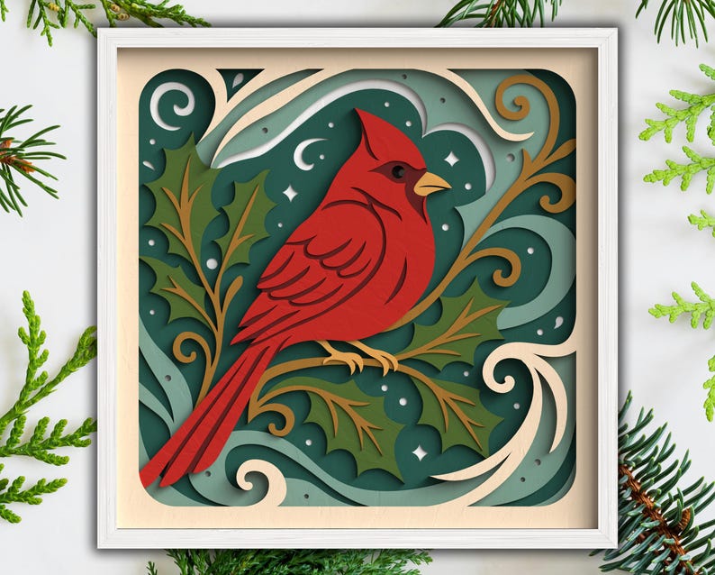 May include: A layered paper art piece featuring a vibrant red cardinal perched on a branch with holly leaves. The artwork is set against a teal background with white accents and a white frame, evoking a festive, nature-inspired theme.