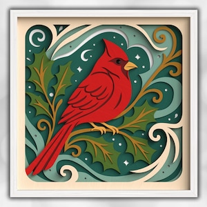 May include: A framed paper art piece featuring a vibrant red cardinal perched on a branch with green holly leaves. The background has layers of teal, cream, and gold, with white stars and swirls. The artwork is encased in a white square frame.