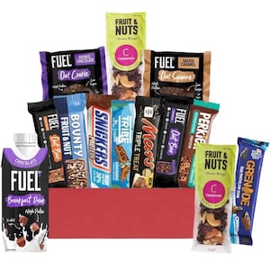 Può includere: Una scatola regalo rossa piena di una varietà di barrette proteiche e una bevanda proteica al cioccolato. Le barrette includono marchi come Fuel, Bounty, Snickers, Tribe, Mars, Perkier e Grenade. La scatola include anche una barretta Fruit & Nuts della gamma classica.