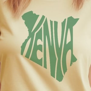 Könnte beinhalten: Ein hellgelbes T-Shirt mit einer grünen Umrandung des Landes Kenia, wobei das Wort "KENYA" innerhalb der Umrandung ausgeschrieben ist.