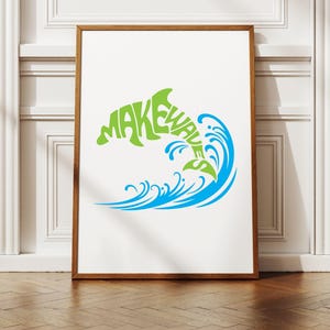 May include: A framed art print featuring a green dolphin leaping from a blue wave. The word "MAKEWAVE" is integrated into the dolphin's form. The artwork is set against a white background.