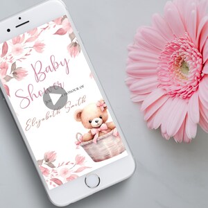 May include: A pink and white baby shower invitation with a floral design and a teddy bear in a basket. The text on the invitation reads "Baby Shower for Elizabeth Smith".