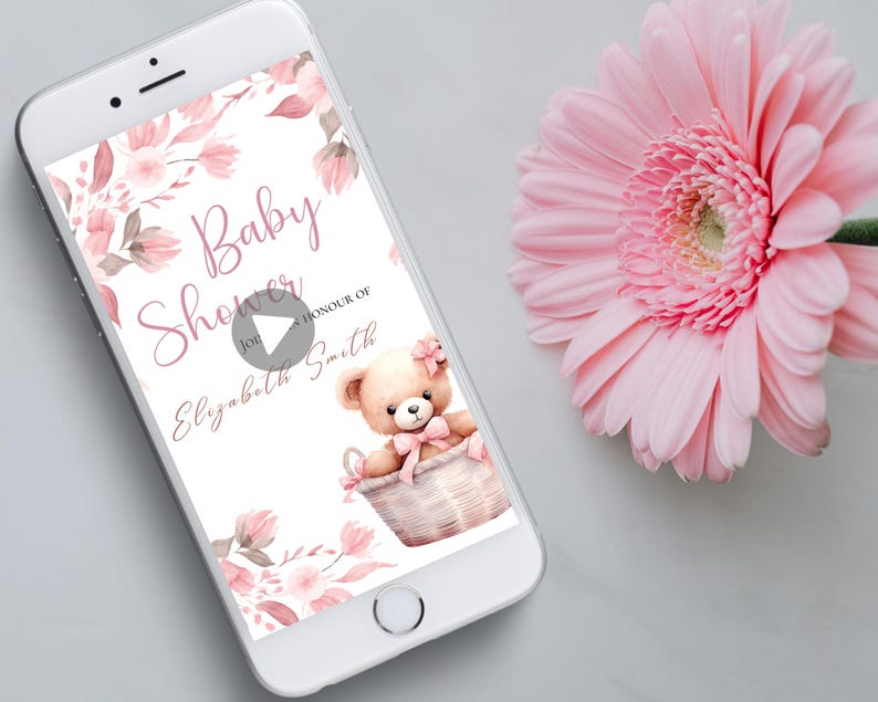 May include: A pink and white baby shower invitation with a floral design and a teddy bear in a basket. The text on the invitation reads "Baby Shower for Elizabeth Smith".