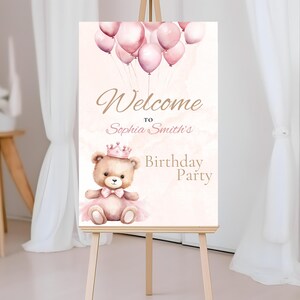 Op de afbeelding: Welkom op Sophia Smith's verjaardagsfeest bord met een roze en bruine teddybeer die een kroon en een roze tutu draagt. Het bord heeft een aquarel achtergrond met roze ballonnen.