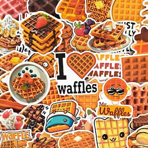 Puede incluir: Una colección de pegatinas de gofres coloridas con varios diseños. Algunas pegatinas presentan gofres con ingredientes como fresas, salsa de chocolate y crema batida. Otras pegatinas tienen el texto "I love waffles" y "Mr. Waffles".