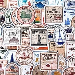 Puede incluir: Una colección de pegatinas con temática de viajes que presentan monumentos emblemáticos y nombres de ciudades. Los diseños incluyen la Torre Eiffel, la Estatua de la Libertad, el Big Ben y el Golden Gate. Las pegatinas son de varias formas y colores, con texto y fechas.