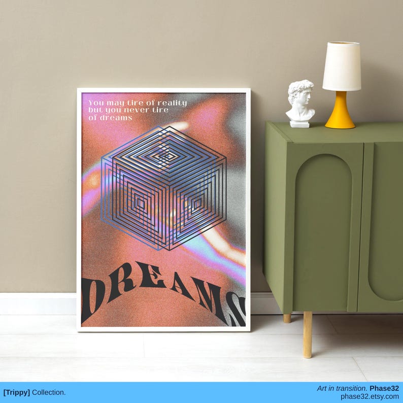 Framed art print with warped geometric shapes and the word "DREAMS" distorted across a surreal pink-orange gradient background, styled on a green cabinet.