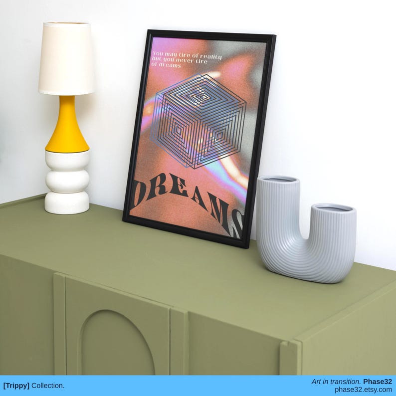 Framed poster print on a green cabinet between two ceramic vases and a yellow lamp, showcasing surreal design and “DREAMS” text.
