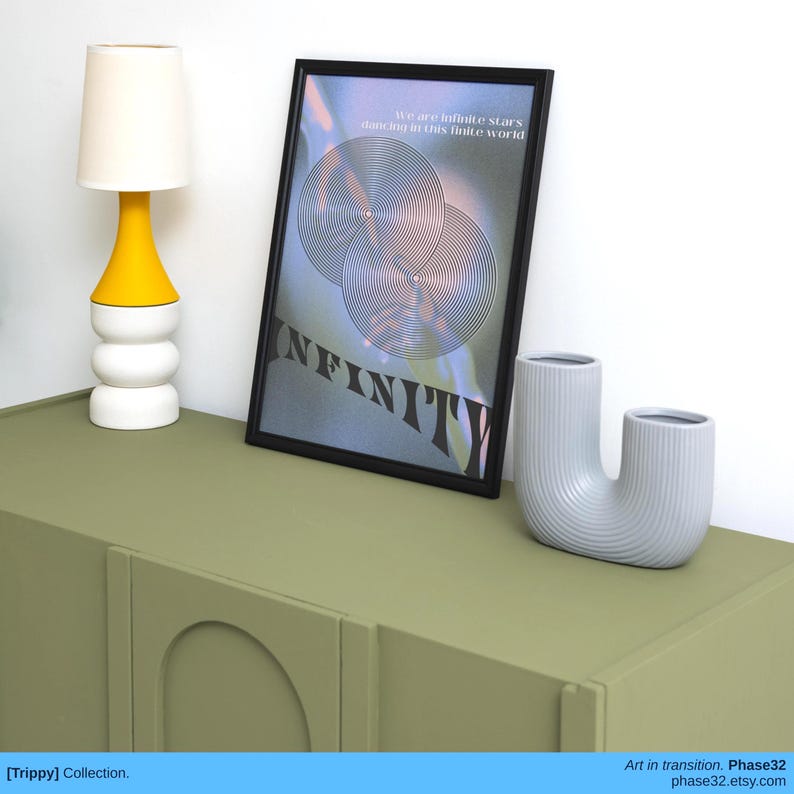 "Infinity" print on display beside a lamp and ceramic vases in a modern, neutral-toned setup.
