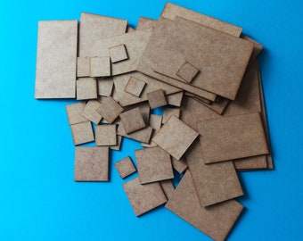 Peut inclure: Un tas de carrés et de rectangles en bois brut de différentes tailles, de couleur brun clair, sur un fond bleu.
