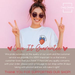 May include: White t-shirt with a strawberry graphic and the words "freedom, democracy, truth". The strawberry has a blue bow and red star pattern. The model is wearing heart-shaped sunglasses and making a peace sign.