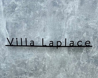 May include: A gray concrete wall with the text "Villa Laplace" written in black letters.