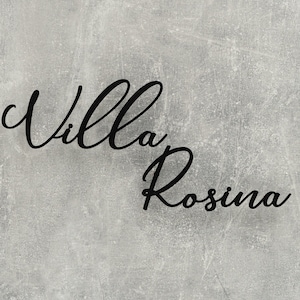 Puede incluir: Una imagen en blanco y negro del texto "Villa Rosina" escrito en cursiva sobre un fondo gris texturizado.