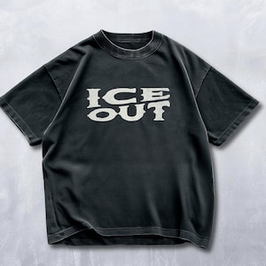 Puede incluir: Camiseta negra con el texto "ICE OUT" en una fuente estilizada de color crema. La camiseta tiene mangas cortas y cuello redondo. La tela parece ligeramente descolorida, d&aacute;ndole un aspecto vintage.