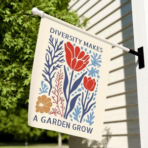 May include: A garden flag with the text "DIVERSITY MAKES A GARDEN GROW" and a floral design. The design features red tulips, blue and brown botanical elements, and is set against a cream background. The flag is hanging outside.