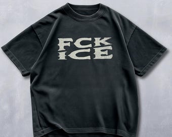 May include: Black short-sleeved t-shirt with the text "FCK ICE" in a distressed, off-white font. The shirt has a crew neck and a slightly faded appearance, suggesting a vintage or worn look. The overall style is casual and streetwear-inspired.