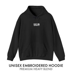 Puede incluir: Sudadera con capucha unisex negra con bolsillo delantero y capucha. El texto blanco "ICE OUT" est&aacute; bordado en el pecho. La parte inferior de la imagen dice "UNISEX EMBROIDERED HOODIE PREMIUM HEAVY BLEND".