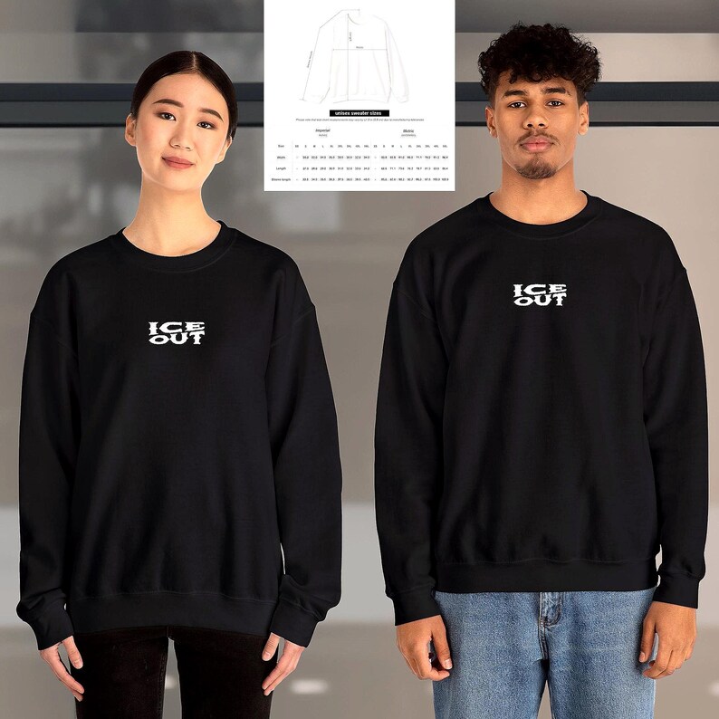 Puede incluir: Sudadera negra de cuello redondo con el texto blanco "ICE OUT" en el pecho. La sudadera la llevan dos personas. Una tabla de tallas es visible en el fondo. La sudadera es de estilo unisex.