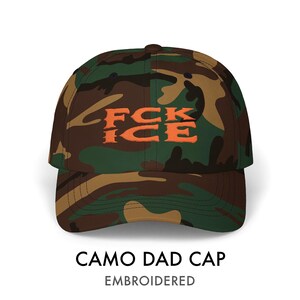 May include: A camouflage dad cap with the embroidered text "FCK ICE" in orange. The hat features a classic six-panel design with a curved brim. The cap is made of a durable fabric and is suitable for everyday wear.