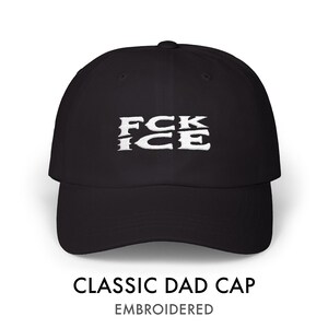 May include: Black classic dad cap with the embroidered text "FCK ICE" in white. The cap has a curved brim and a structured fit. The text "CLASSIC DAD CAP" and "EMBROIDERED" are displayed below the cap.